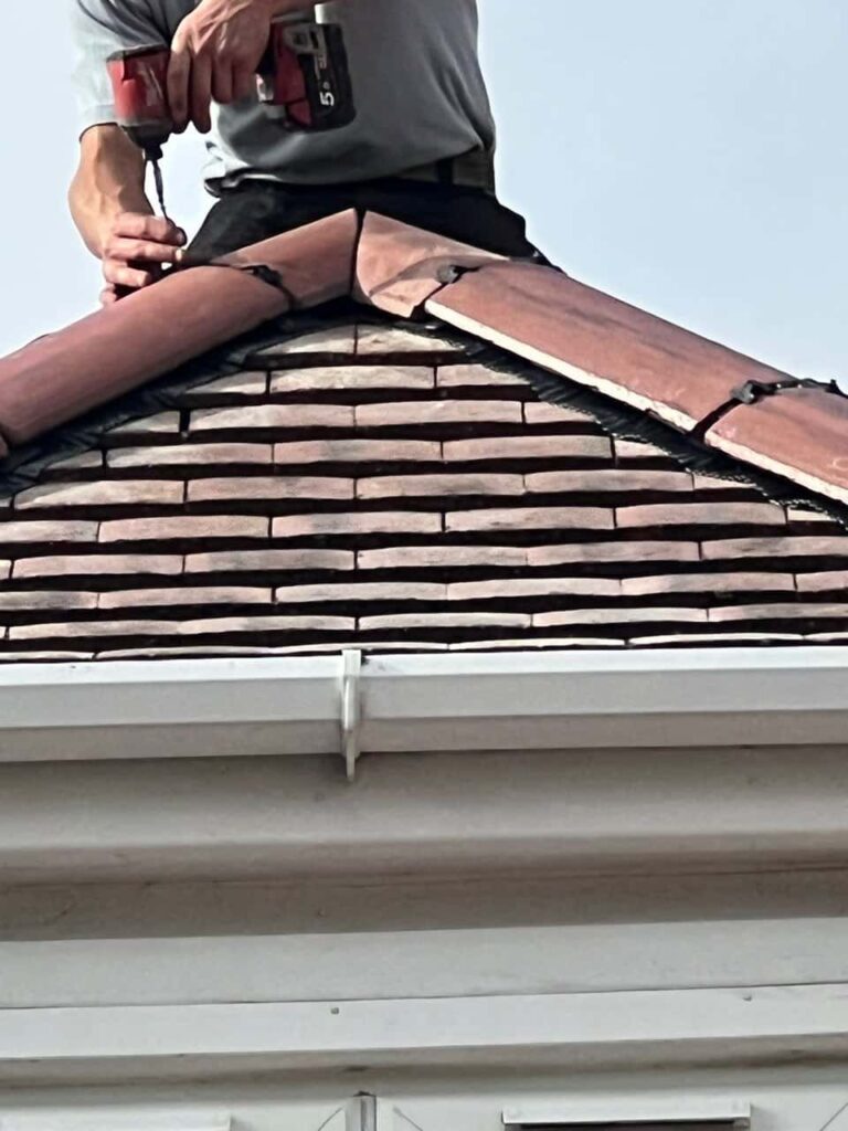 This is a photo of one of the operatives of Burton Joyce Roofing Repairs installing new ridge tiles