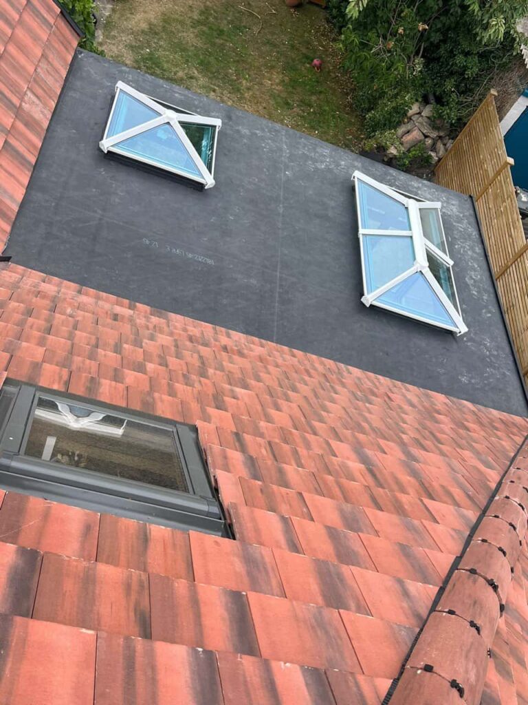 This is a photo taken from the roof ridge looking down a tiled pitched roof on to a flat roof. Works carried out by Burton Joyce Roofing Repairs