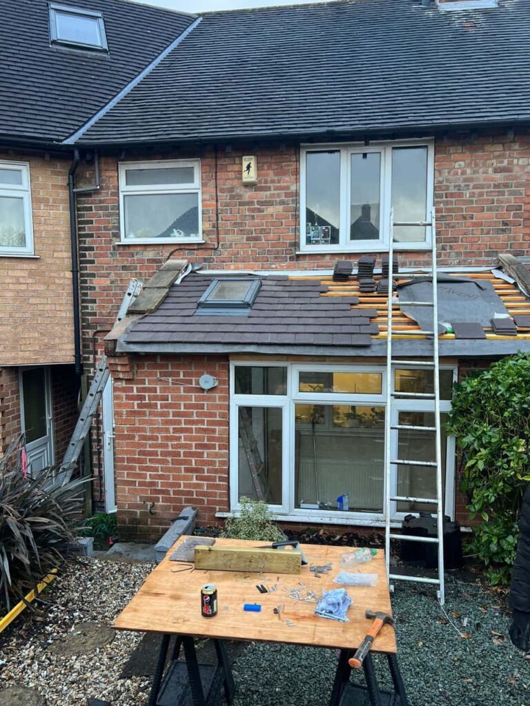 This is a photo of a roof extension that is having new roof tiles installed. This is a photo taken from the roof ridge looking down a tiled pitched roof on to a flat roof. Works carried out by Burton Joyce Roofing Repairs